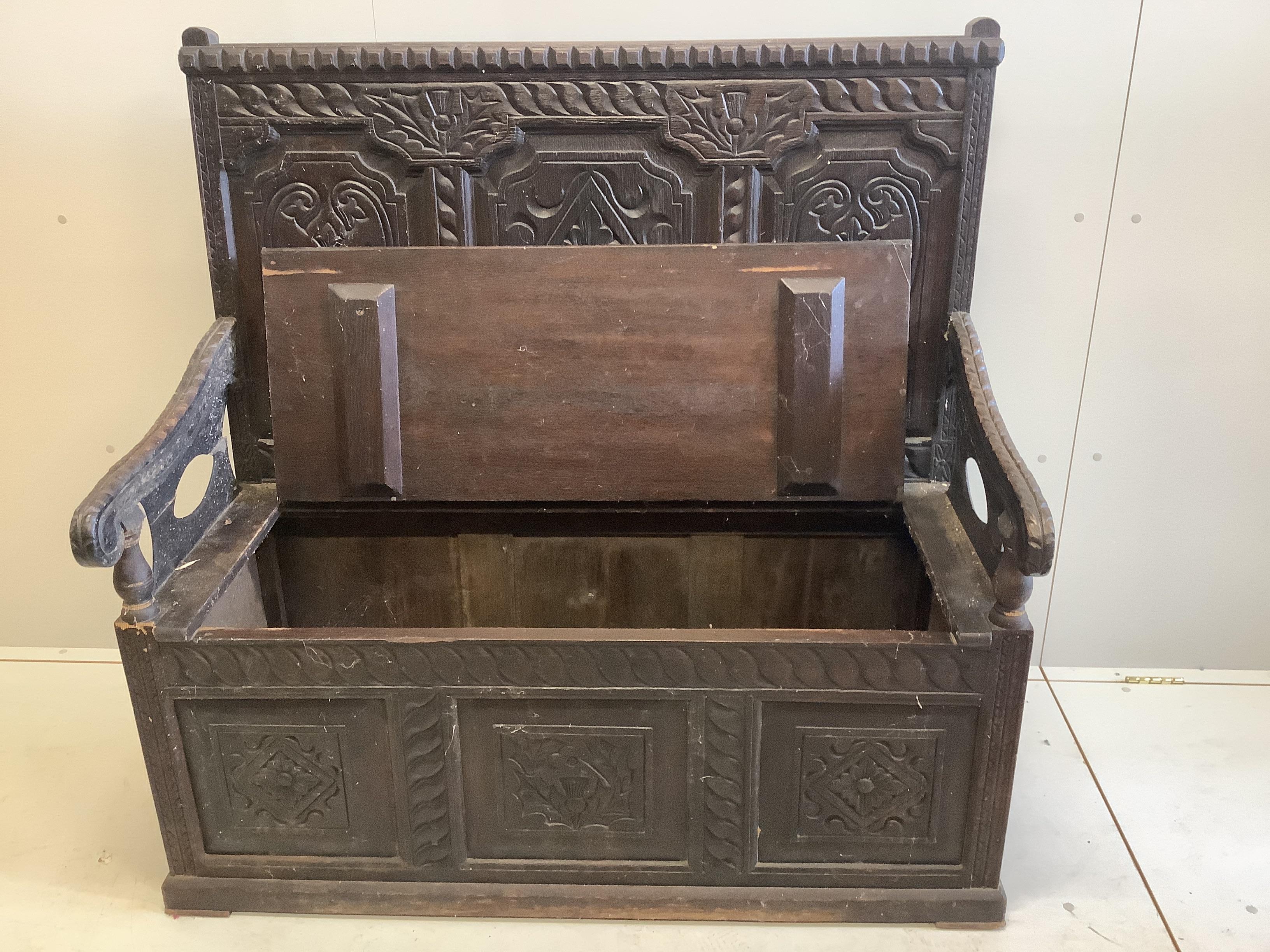 An early 20th century carved oak box seat settle, width 122cm, depth 56cm, height 121cm